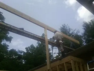 Carpenter setting a ridge beam over a new addition frame — Ice Dam Removal by Roofing Brothers in Nicholasville