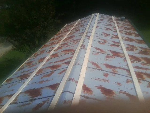Rusted metal roof panels with new wood purlins before replacement — Storm Damage Roof Repair in Nicholasville by Roofing Brothers