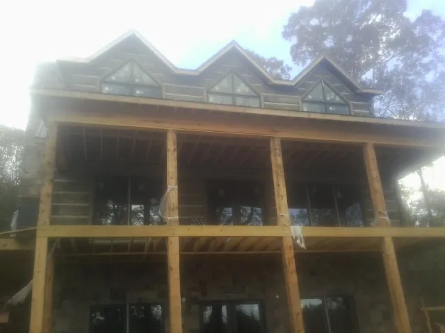 Dormers and porch framing on a large log home under construction — Roof Coating work by our crew in Nicholasville