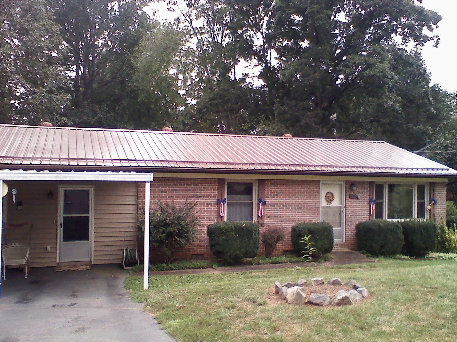 Bronze metal roof and carport on a brick ranch home — Roof Repair work by our crew in Nicholasville